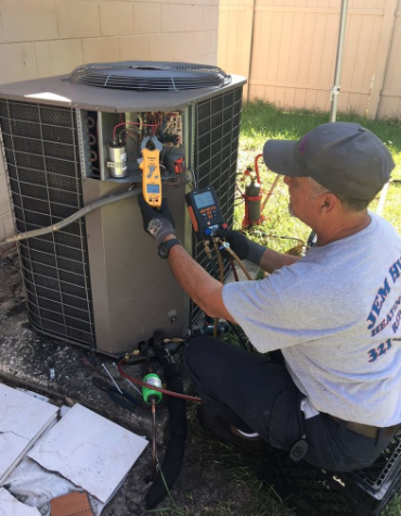 JEM HVAC owner and contractor checking and troubleshooting air conditioning equipment.
